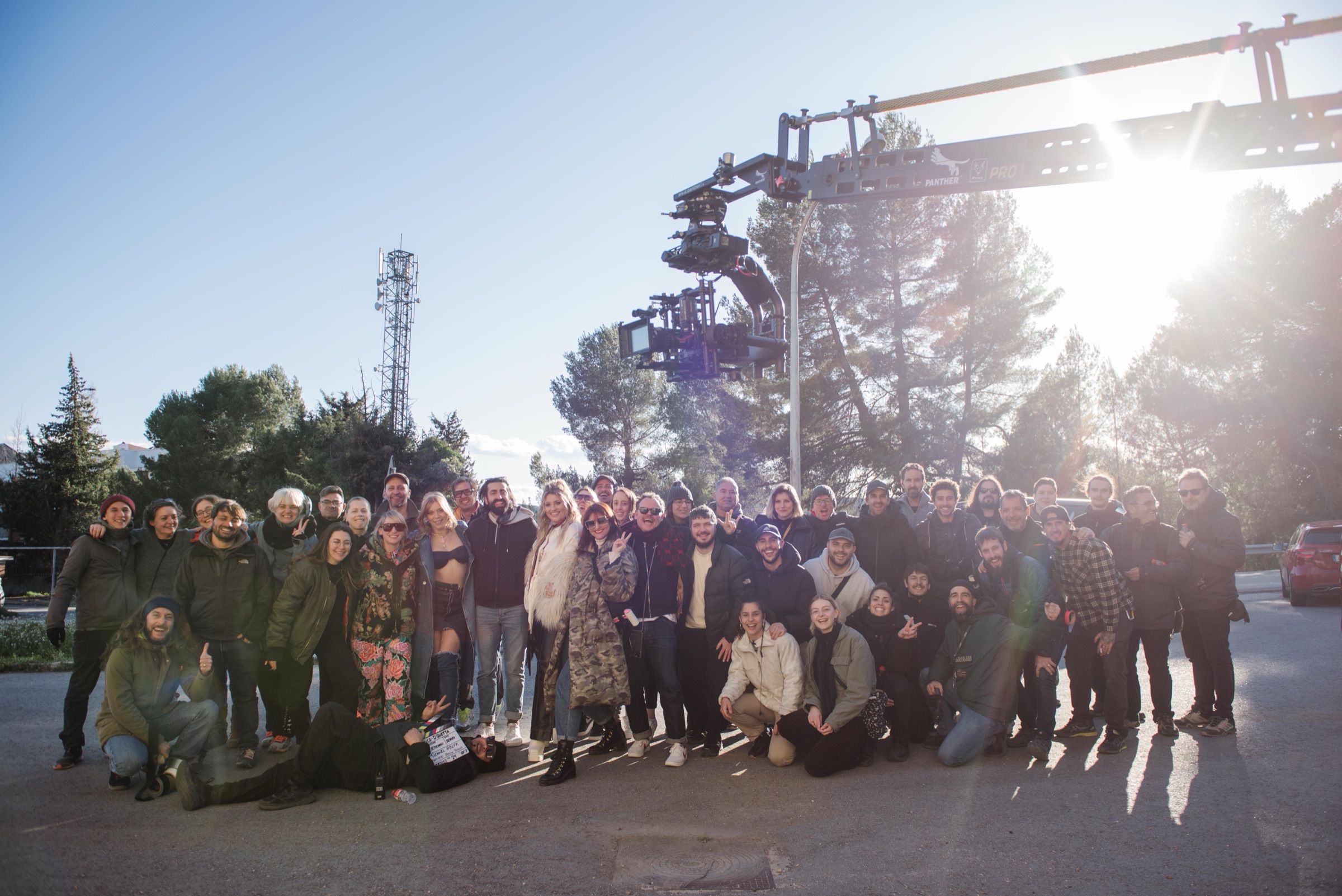The full crew on set beneath a camera crane